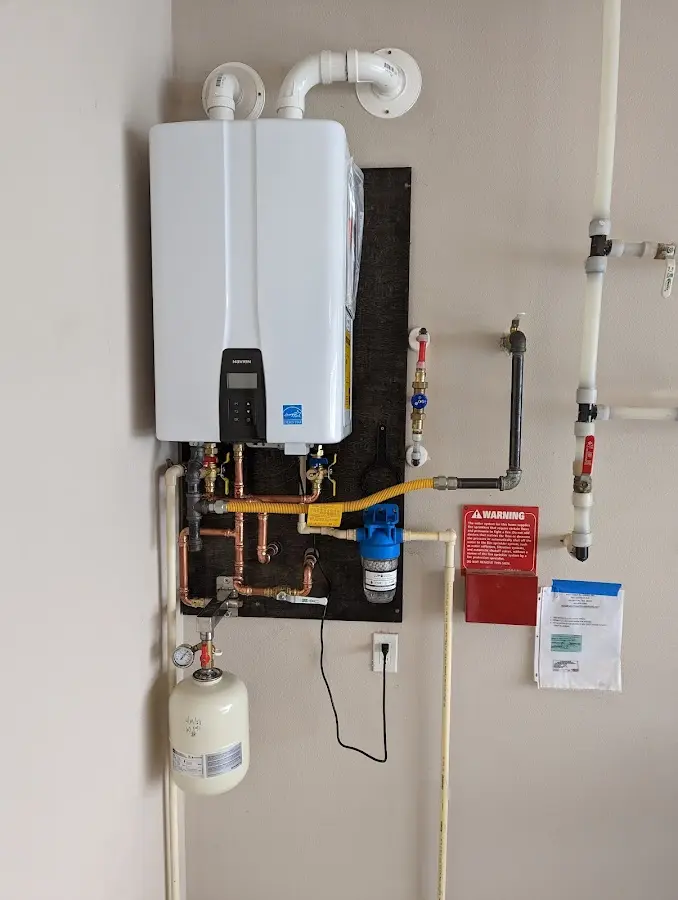 Professional plumber installing copper piping in a Mount Angel home